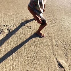 Low section of people walking on sand