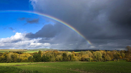 Scenic view of rainbow over field against sky