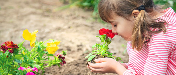 Side view of girl smelling flower