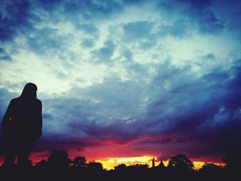 Silhouette person standing against sky during sunset