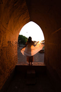 Rear view of woman standing in tunnel