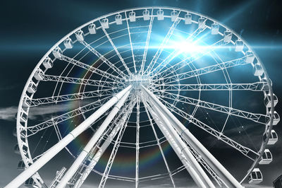 Low angle view of illuminated ferris wheel against sky at night