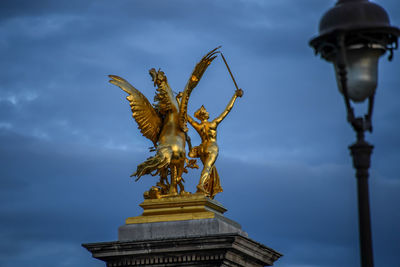 Low angle view of angel statue against sky