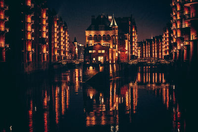 Reflection of buildings in lake at night