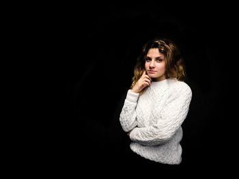 Portrait of a beautiful young woman over black background