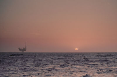 Oil platform and a hazy sunset. 