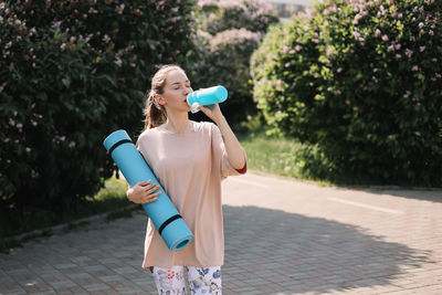 Athletic happy healthy young woman in sportswear goes after a sports workout exercise in nature