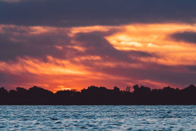 Scenic view of lake against romantic sky at sunset