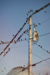 Low angle view of electricity pylon against clear sky