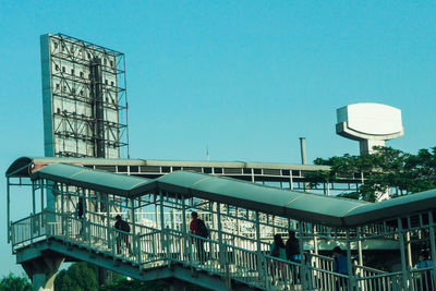 People on basketball court against clear blue sky