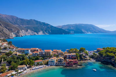 High angle view of sea and mountains against clear blue sky