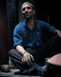 Happy worker sitting in workshop