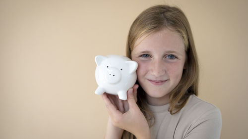 Midsection of woman holding piggy bank on table