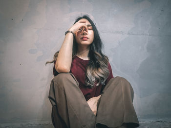 Portrait of beautiful woman against wall