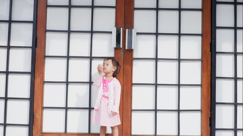 Girl standing against closed door