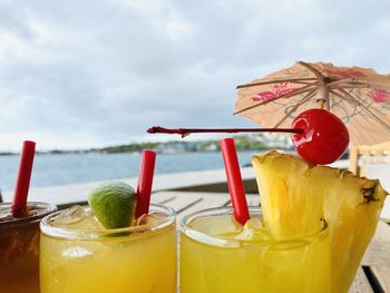 Close up of tropical mai tai sampler with ocean in background.