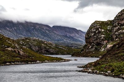 Scenic view of river amidst mountains against sky