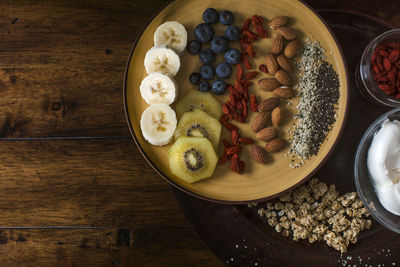 Healthy and delicious plate of fruit, nuts and seeds with yogurt and gogi berries