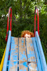 Portrait of girl on slide against plants