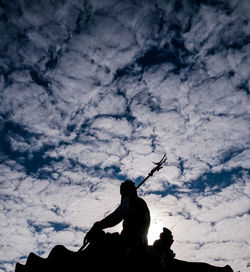 Low angle view of silhouette man against sky