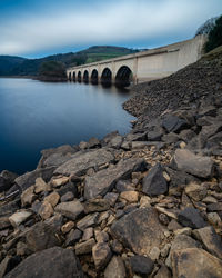 Arch bridge over river against sky