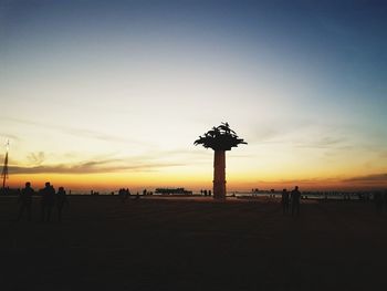 Silhouette people at observation point against sky during sunset