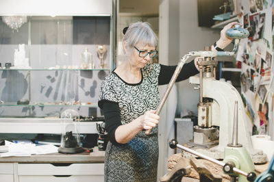 Senior woman working on vise grip in workshop
