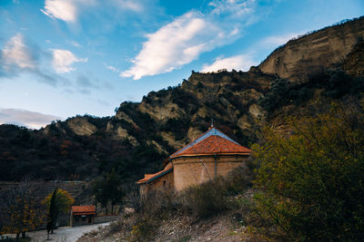 Traditional building by mountains against sky