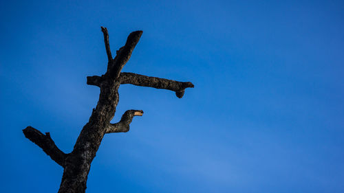 Low angle view of cross against clear blue sky