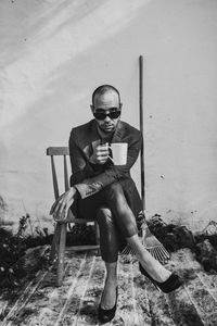 Portrait of young man sitting on wall