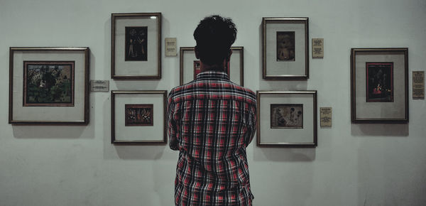 Rear view of man standing in museum