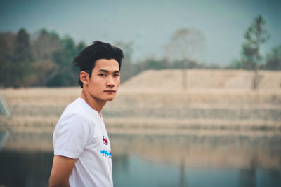 Portrait of young man standing on field