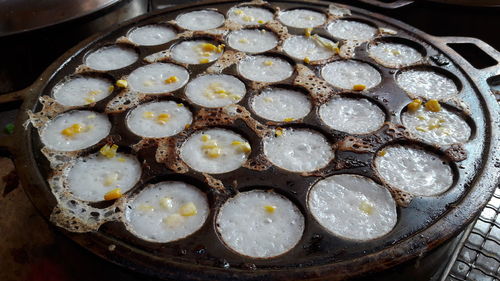 Thai coconut pudding cooked in a pan over a charcoal fire - khanom khrok in thai