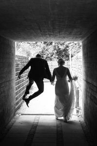 Rear view of couple standing against wall