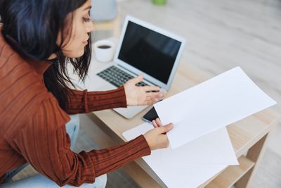 Midsection of woman using laptop on table