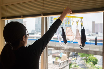 A woman going to hang dry cotton masks. this picture uses a new normal concept.