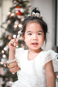 Portrait of smiling girl blowing bubbles while standing outdoors