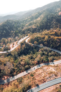 Aerial view of road amidst trees against sky