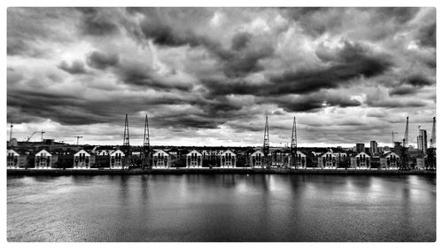 Bridge over river against cloudy sky