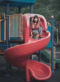Rear view of woman sitting on slide