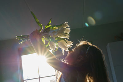 Young girl holding a bouquet from white tullips .