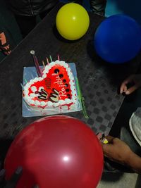 High angle view of hand holding balloons