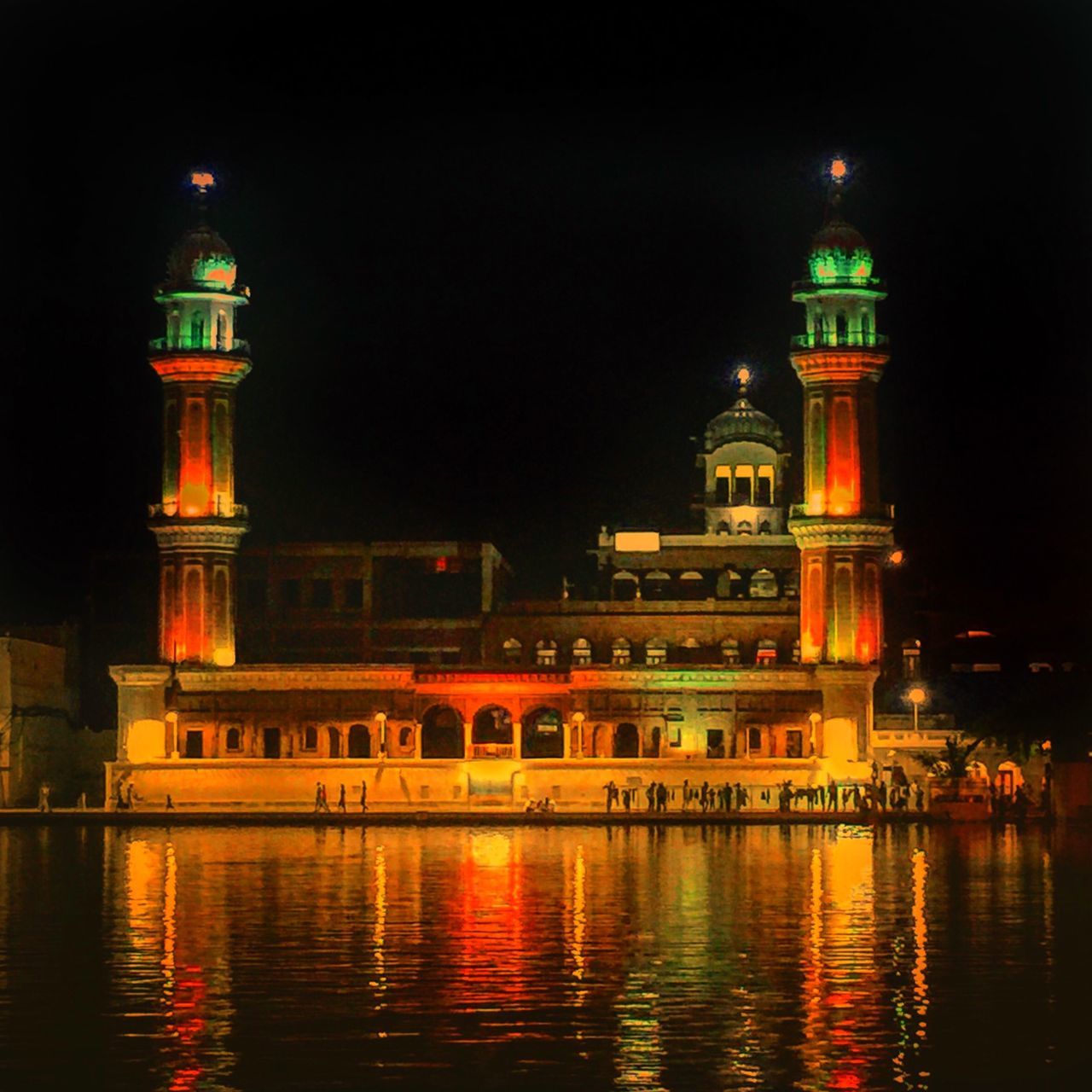 waterfront, building exterior, architecture, illuminated, water, built structure, night, reflection, river, travel destinations, sky, tower, famous place, religion, rippled, outdoors, city, history, clear sky, lighthouse