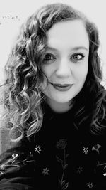 Portrait of smiling young woman against gray background