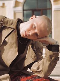 Portrait of man sitting against building