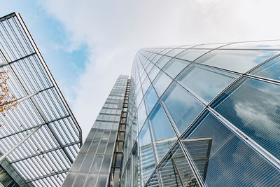 Low angle view of modern glass building against sky