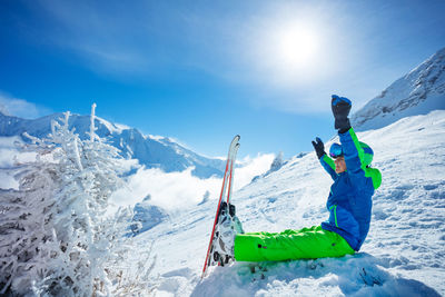 Man skiing on snowcapped mountains against sky