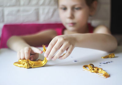 Close-up portrait of a girl sitting on table