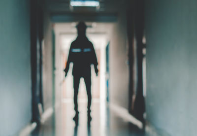 Rear view of man standing in corridor of building