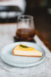 Lemon cheesecake with iced coffee on table